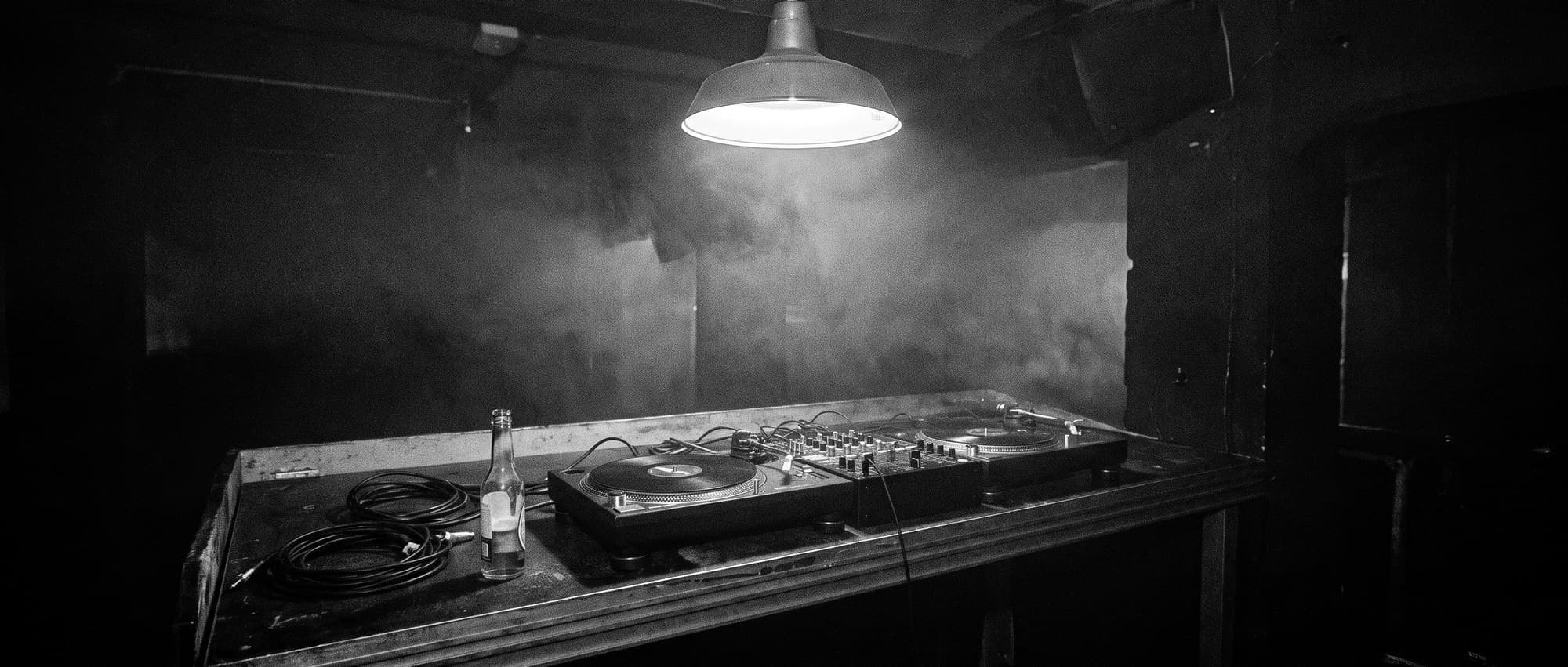An empty DJ booth under a single lamp